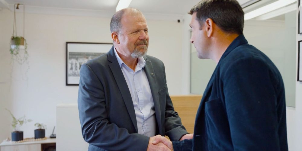 Principal lawyer Paul Mannion shaking hands with a client in the firm's office